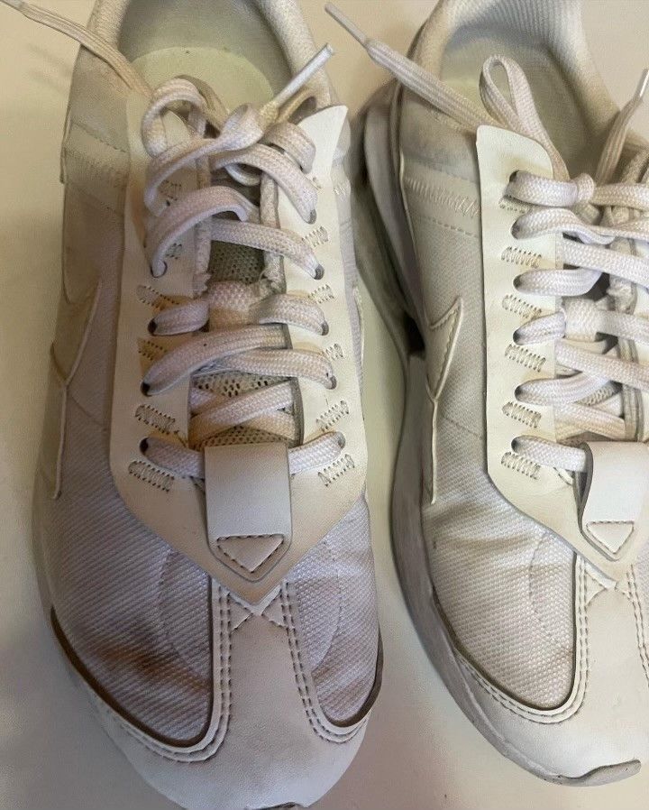 A pair of white sneakers are sitting on a table