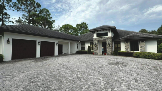 Modern house exterior with double garage, stone driveway, and landscaped front entrance