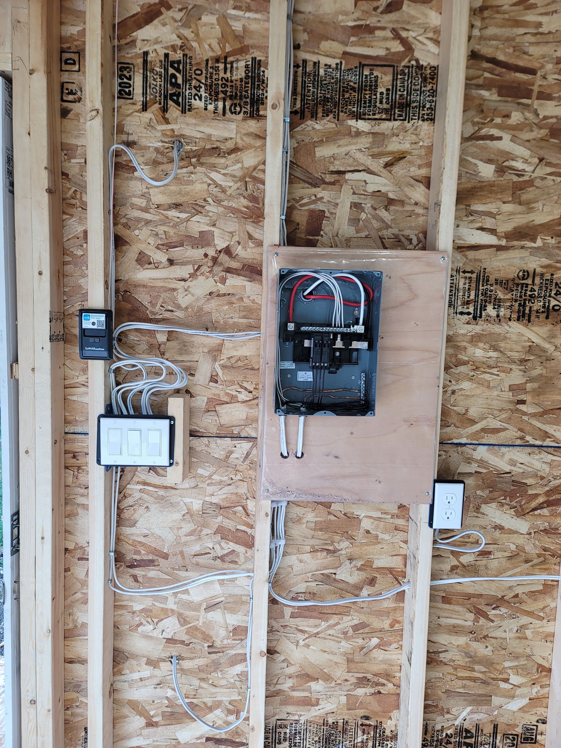 Electrical panel and wiring installed on a wood-framed wall.