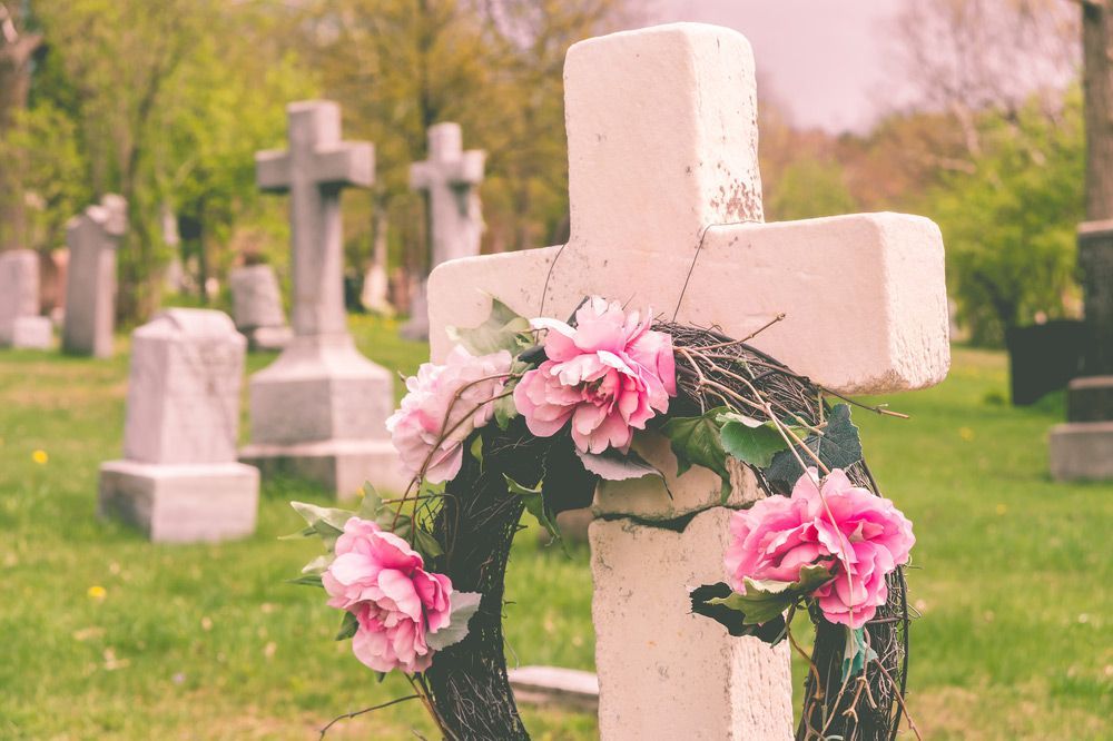 Grave With A Wreath Of Pink Flowers On It In A Cemetery — Northern Rivers Headstones in Ballina, NSW
