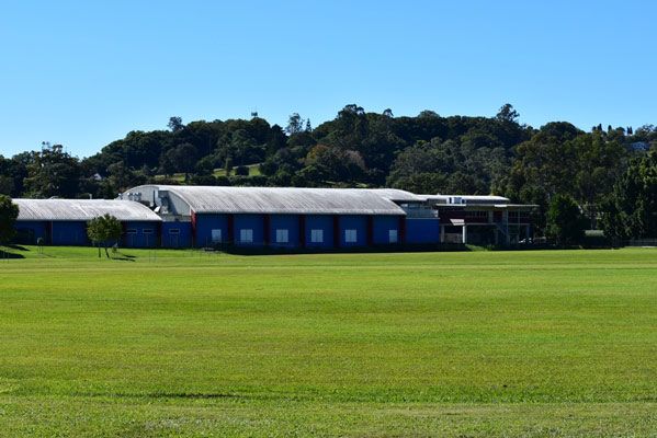 A Large Grassy Field With A Building — Northern Rivers Headstones in Lismore, NSW