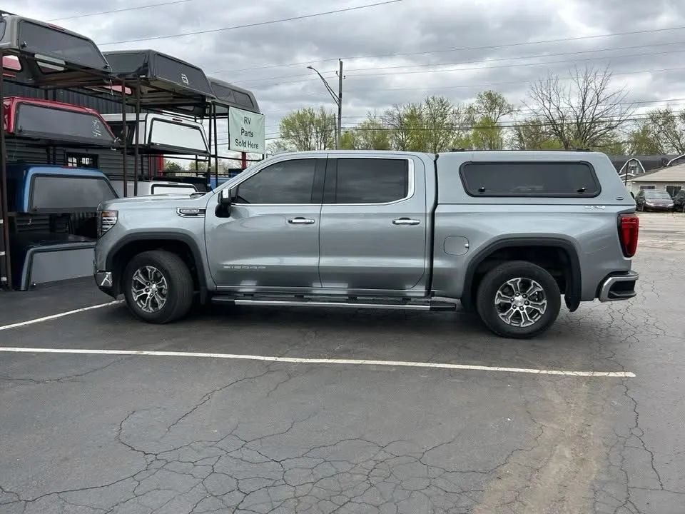 GMC truck fitted with a camper cap at a truck accessories store with caps and inventory visible in the background GMC truck fitted with a camper cap at a truck accessories store with caps and inventory visible in the background