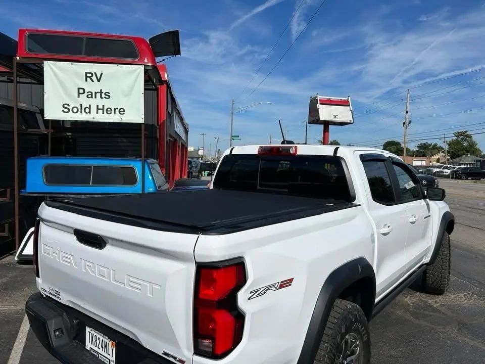 Chevrolet truck with a tonneau cover at a truck accessories store displaying caps and exterior truck accessories