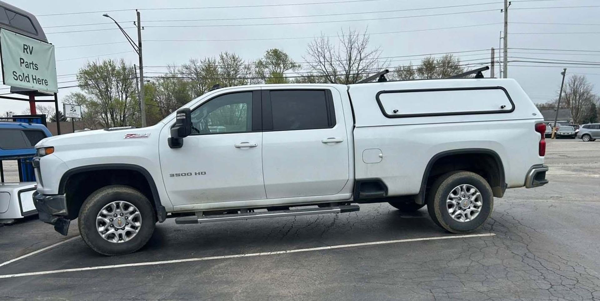White pickup with camper shell parked