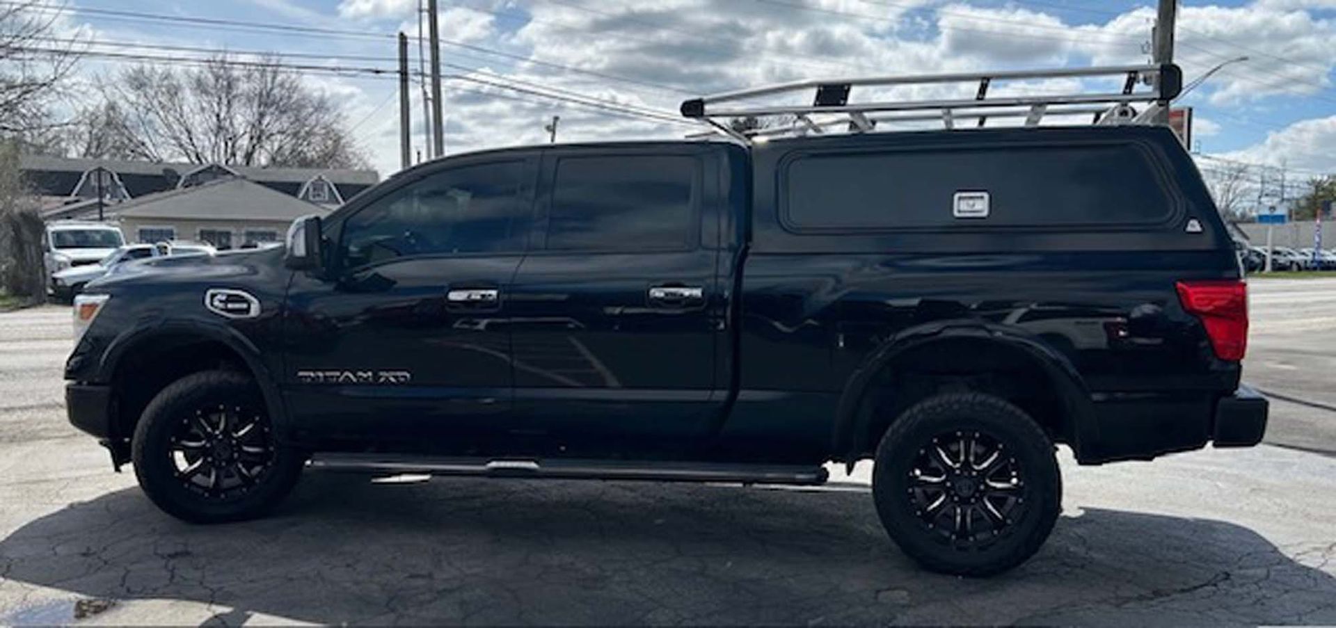 Black Nissan Titan with bed cap, rack