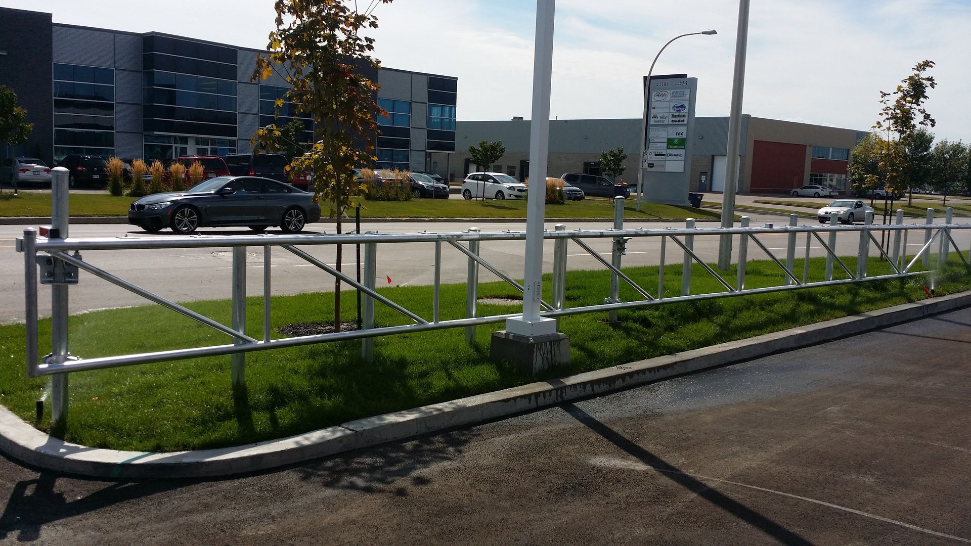 Une voiture passe devant une clôture métallique dans un parking