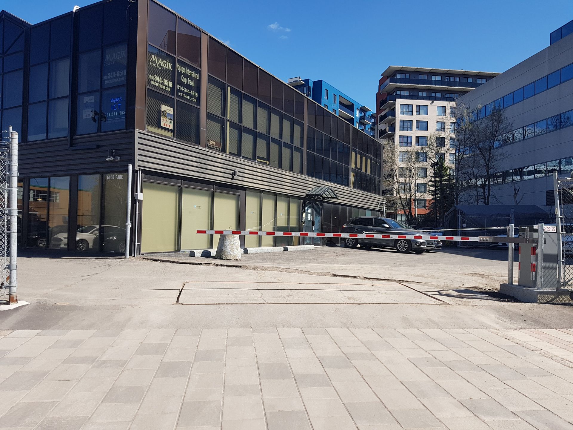 Un parking devant un immeuble avec une barrière