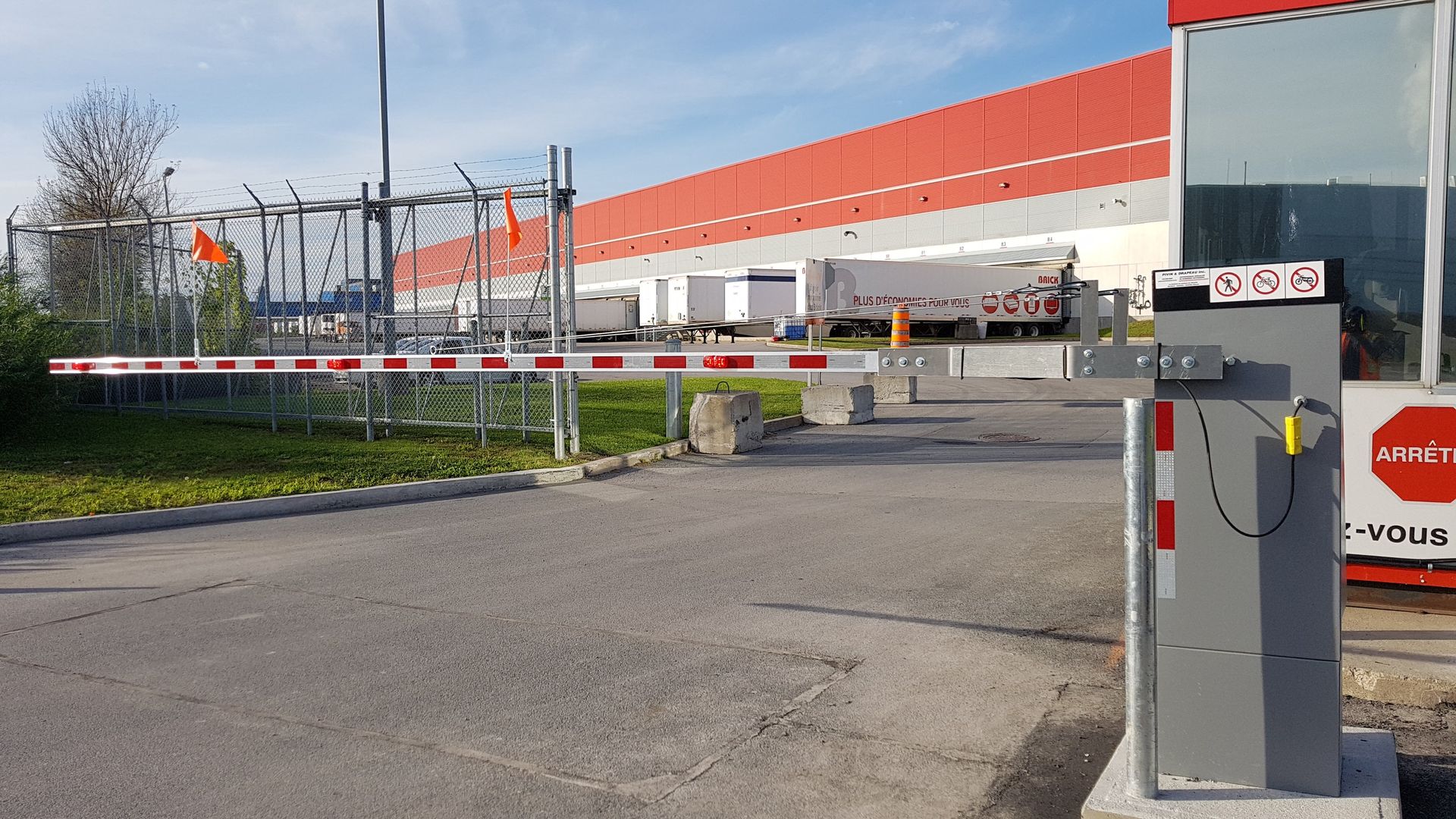 Un entrepôt avec une barrière et un panneau indiquant stop