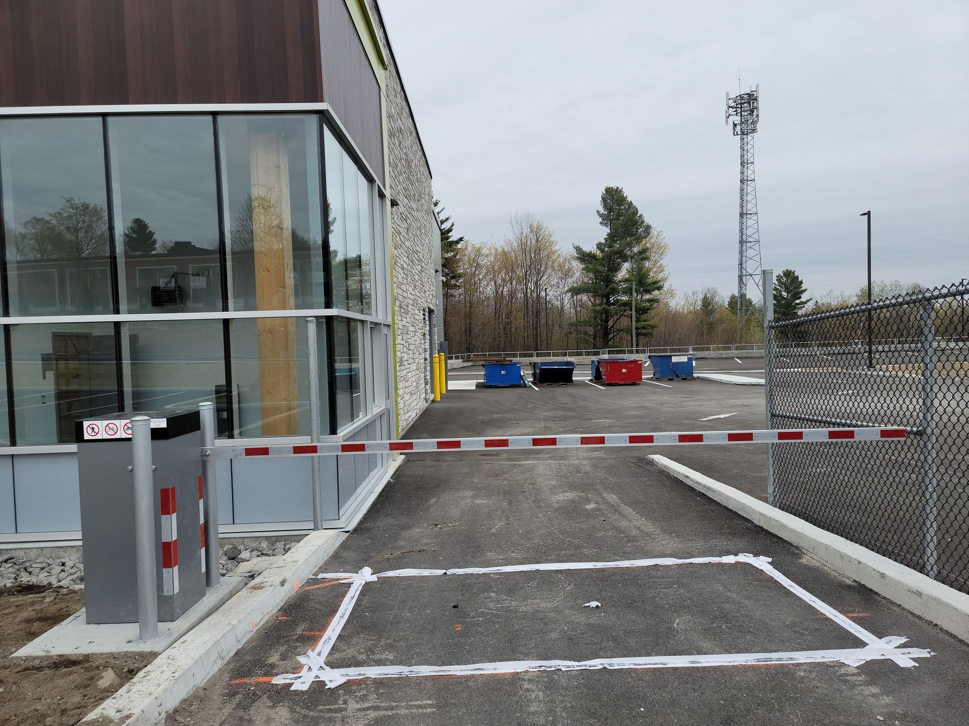 Un parking avec une barrière et un bâtiment en arrière-plan