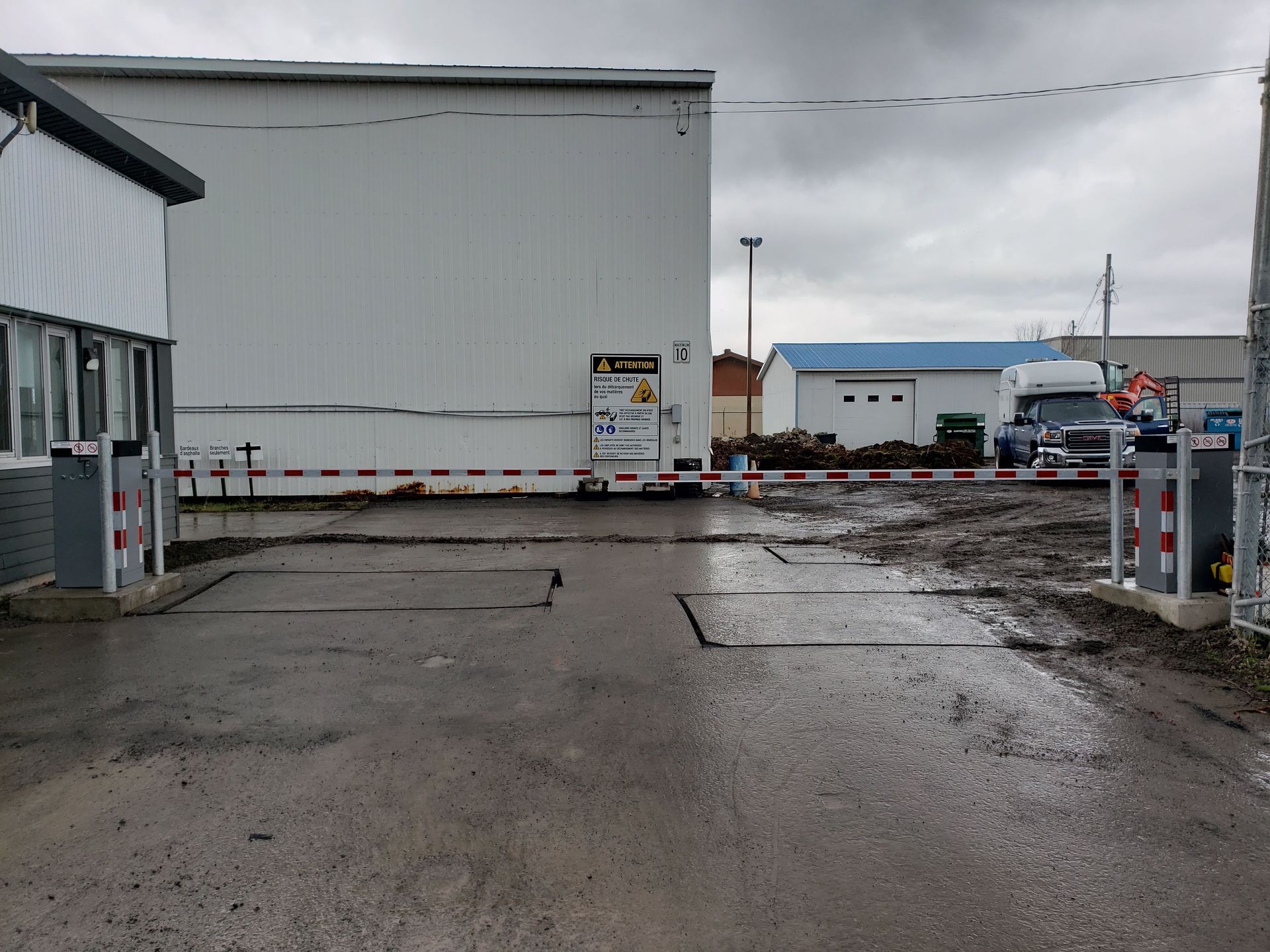 Un parking avec une clôture et un bâtiment en arrière-plan
