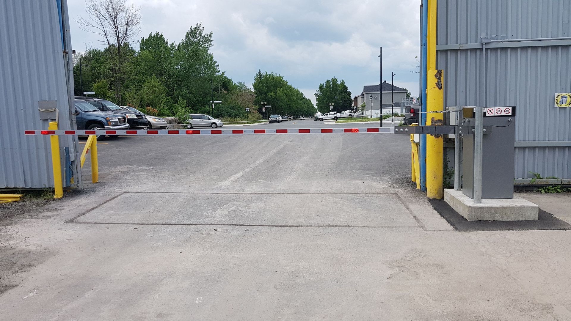 Un parking avec des voitures garées derrière une barrière