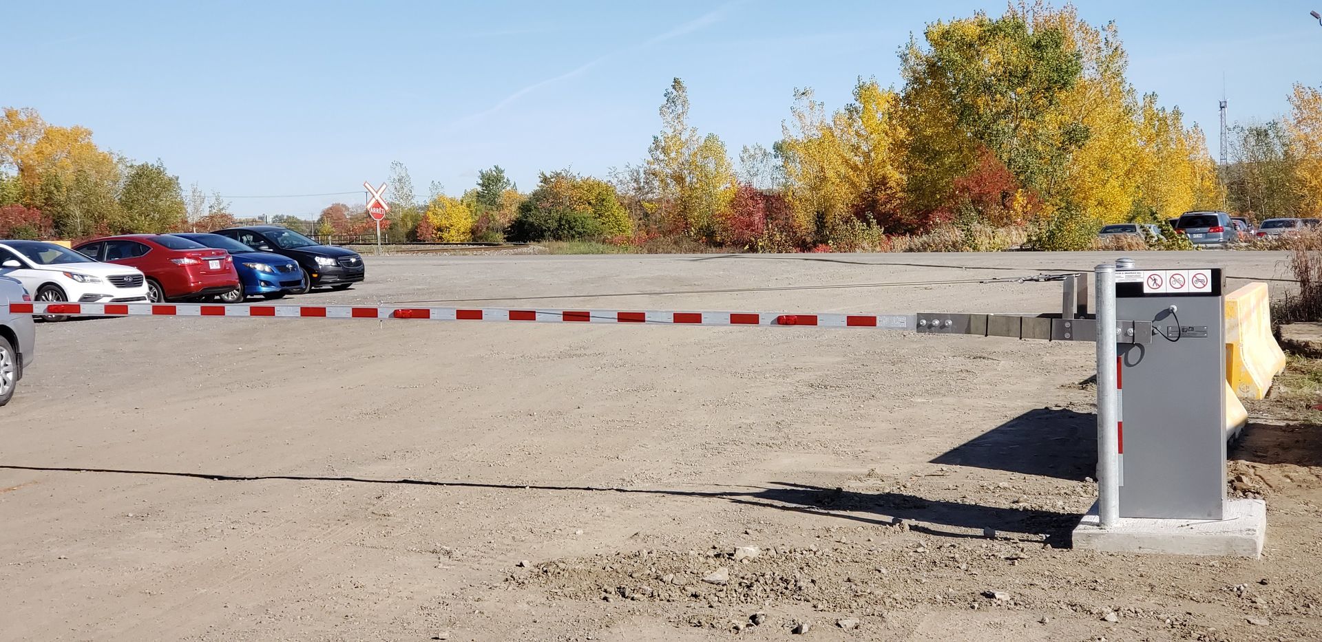 Un parking avec des voitures garées derrière une barrière