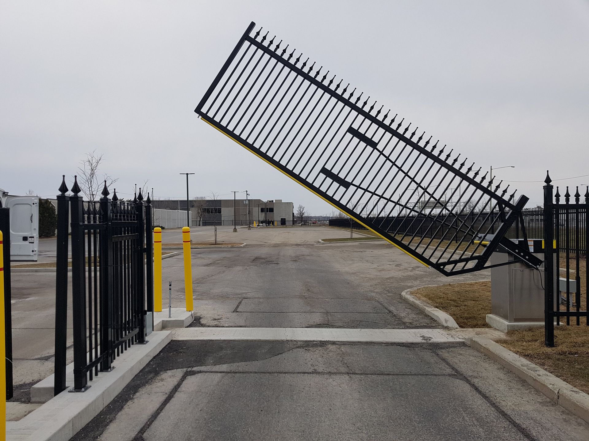 Une porte noire est ouverte sur un parking