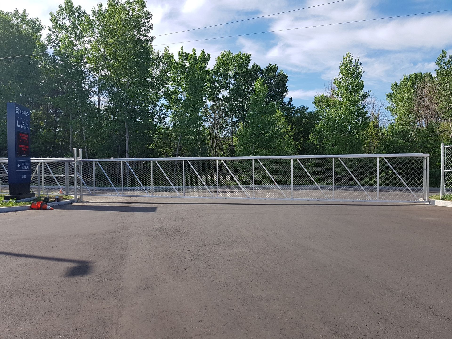 Une grande porte en métal se trouve sur le bord d'une route