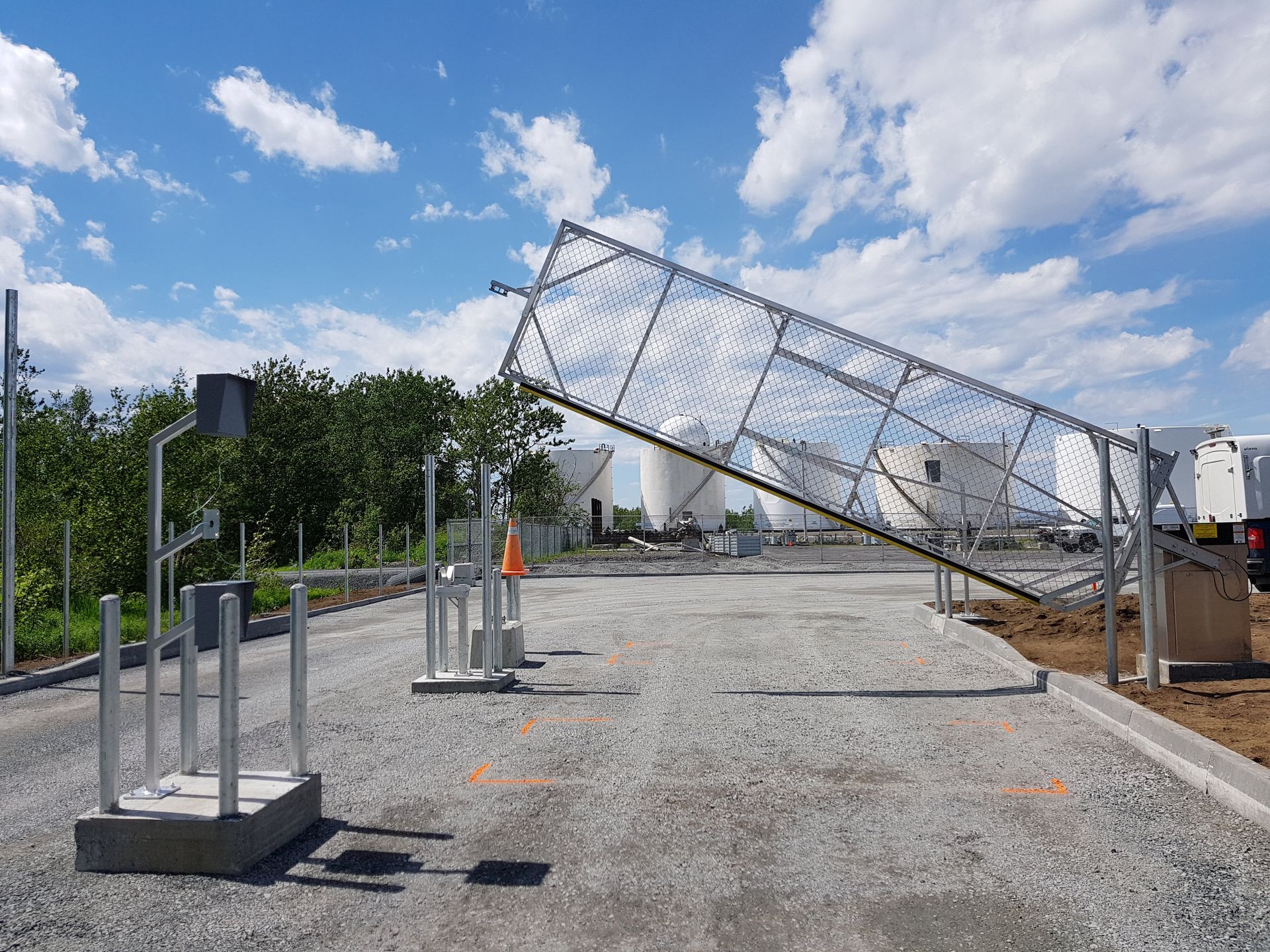 Une grande structure métallique est posée sur une route de gravier.