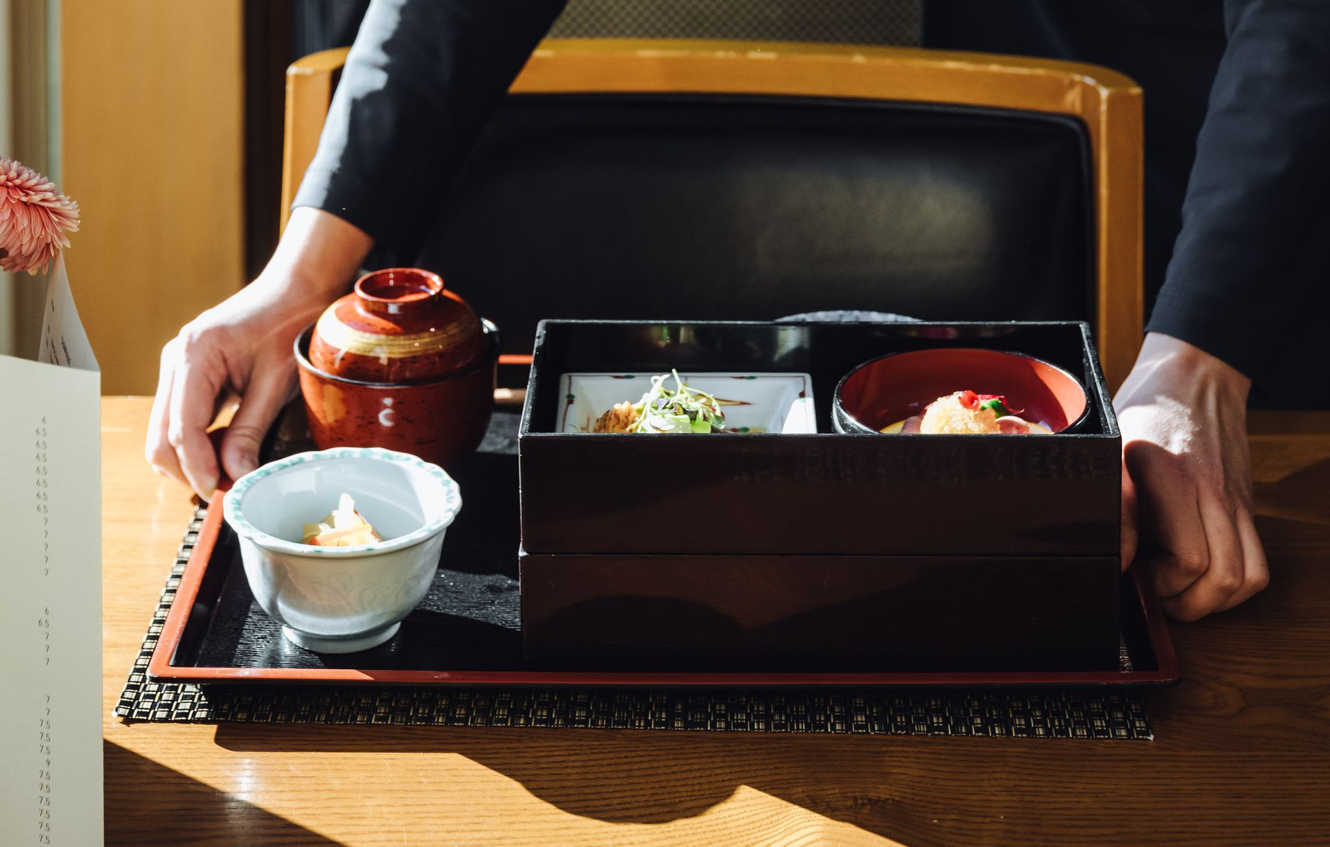 Japanese bento box with various colorful dishes including seafood, vegetables, and rice.