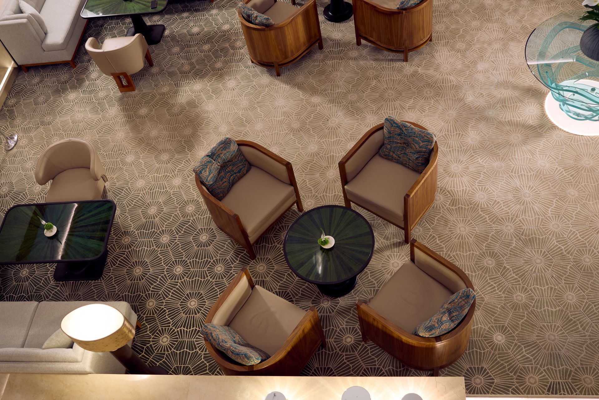 Overhead view of a hotel lounge with seating areas and a rug.