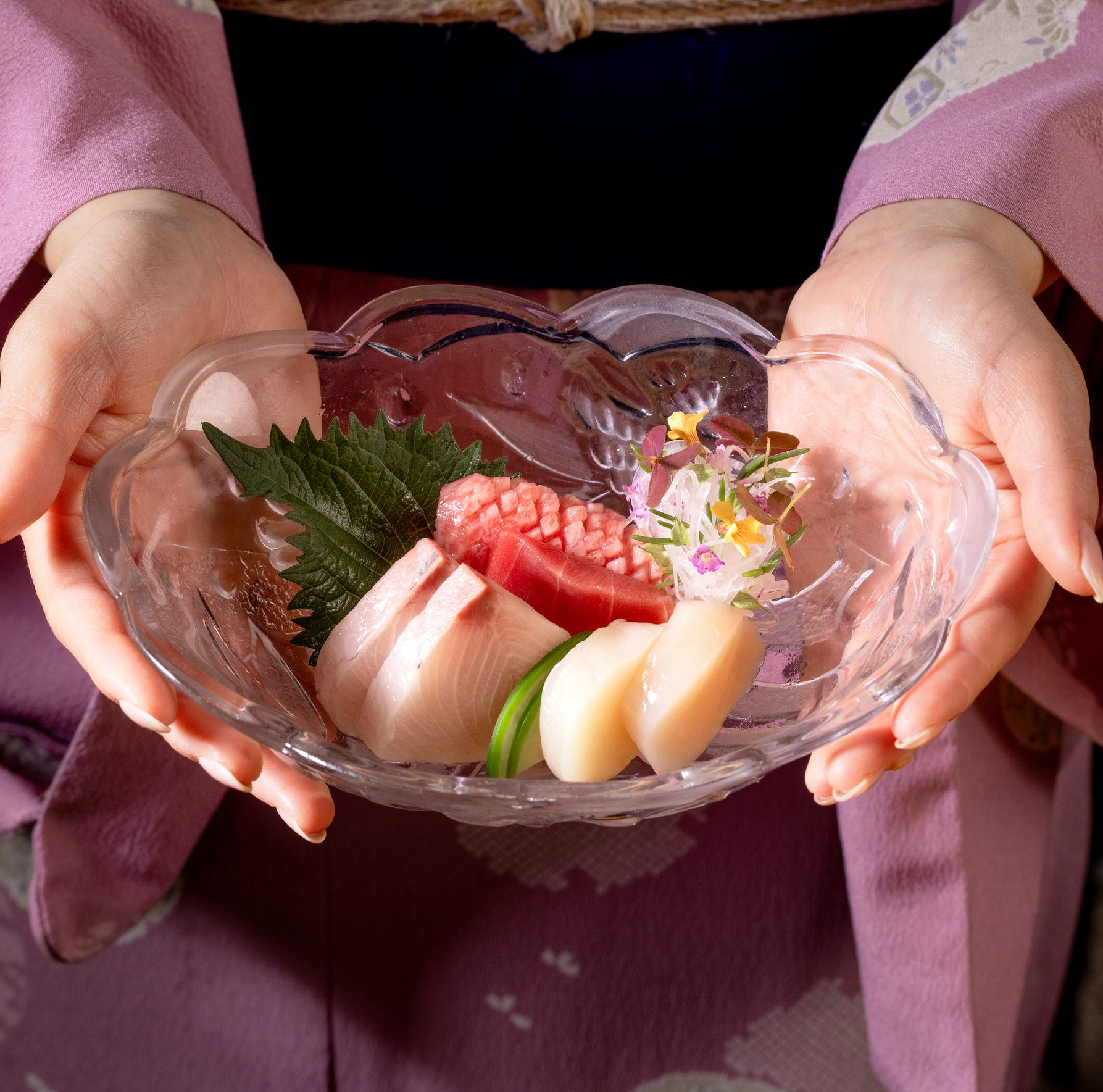 Een vrouw in een kimono dekt een tafel in een restaurant.