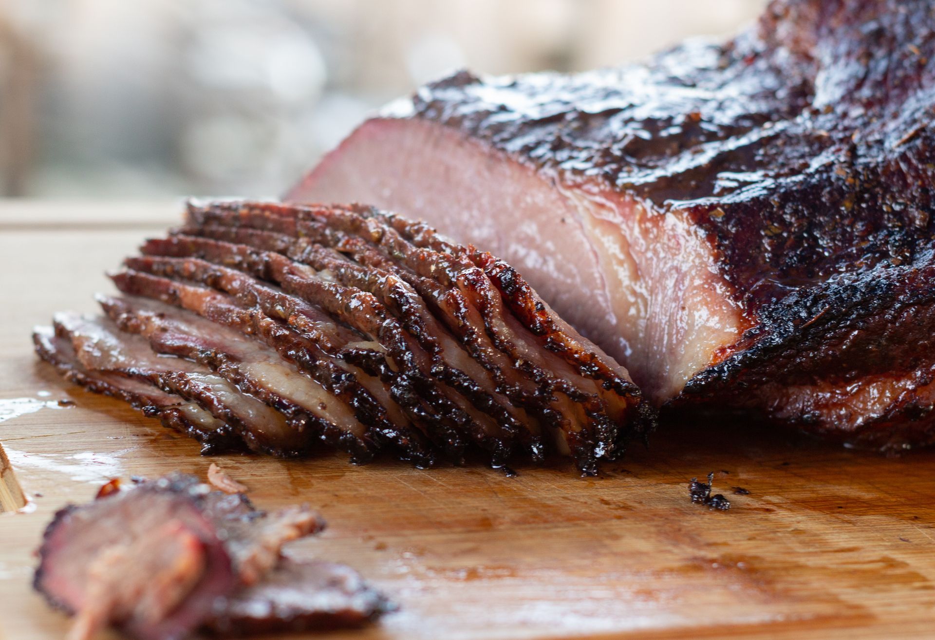A large piece of meat is sitting on a wooden cutting board.
