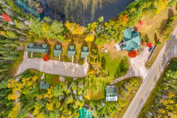 An aerial view of a house surrounded by trees and a lake.