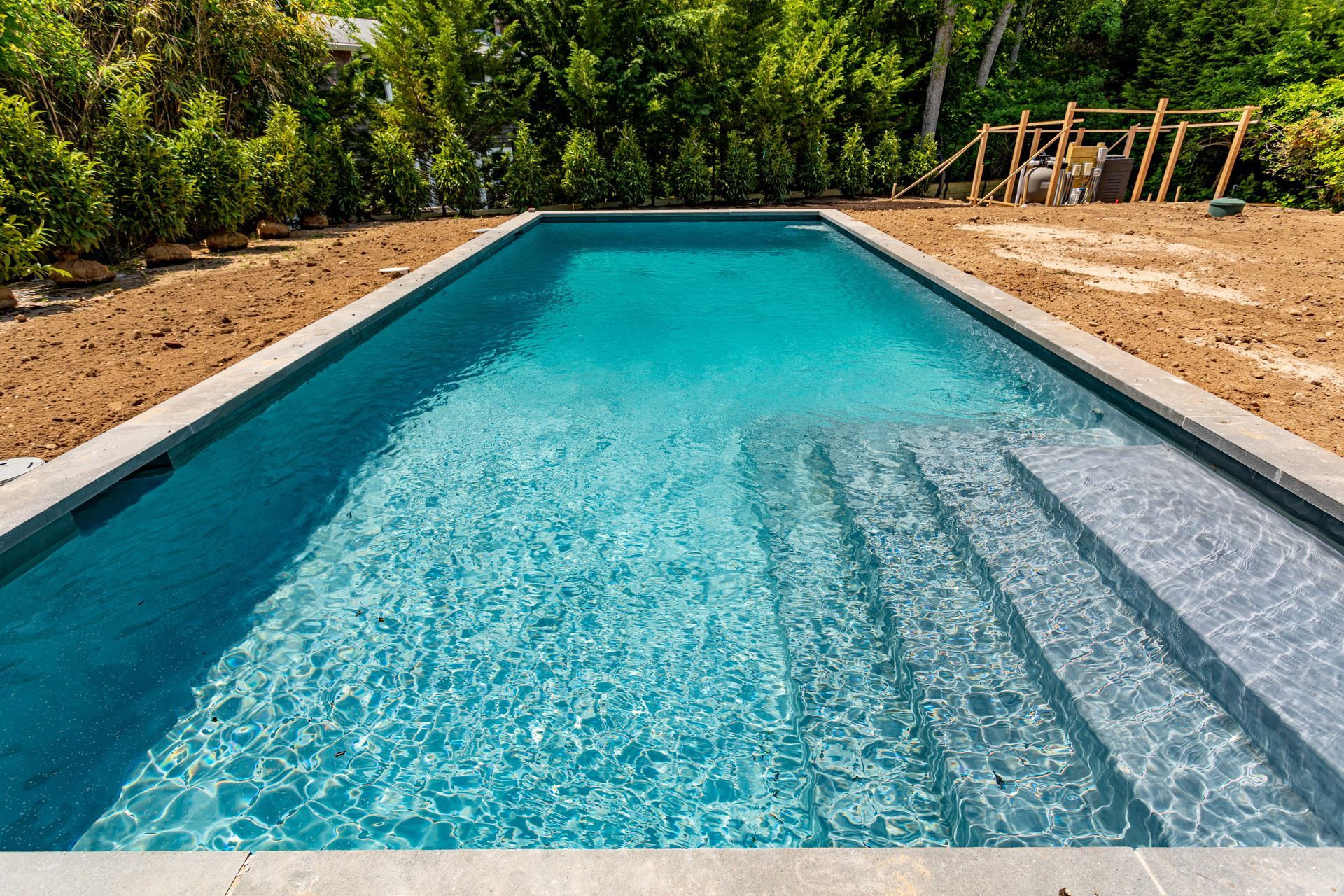 Newly built backyard swimming pool with clean water.