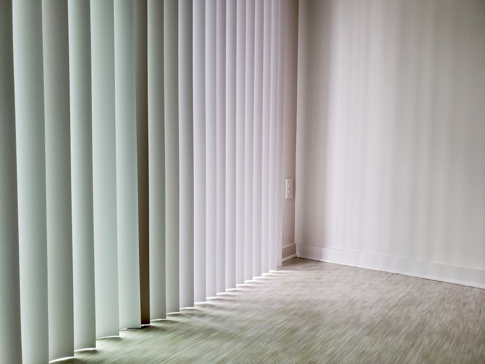 White Vertical Blinds In A Minimalistic Sunlit Room — Ulladulla Blinds & Home Improvements In Ulladulla, NSW