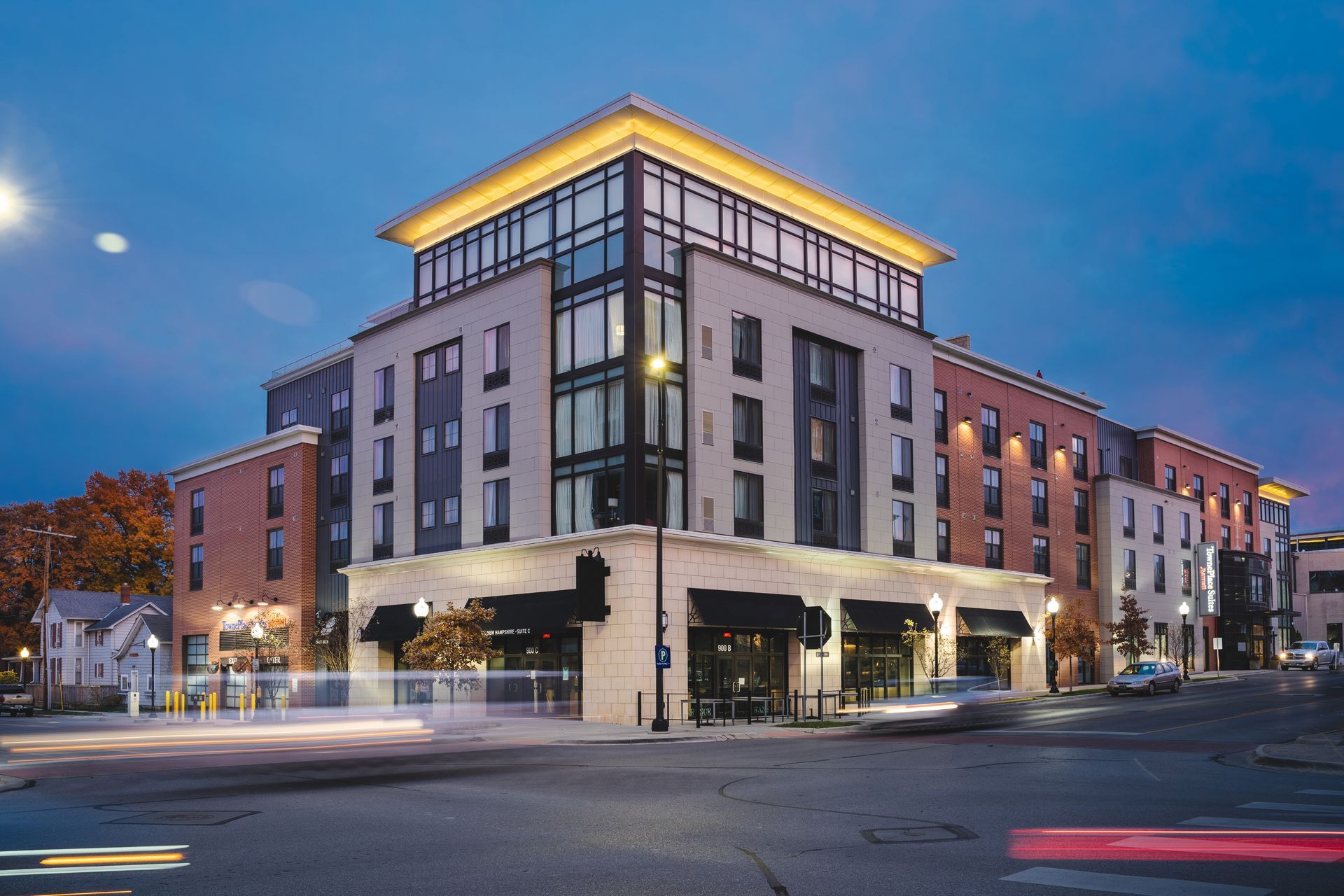 Modern corner office building with lit windows at dusk on a city street