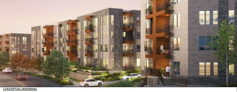 Modern apartment complex with brick and gray facades, trees, and cars along a street at dusk