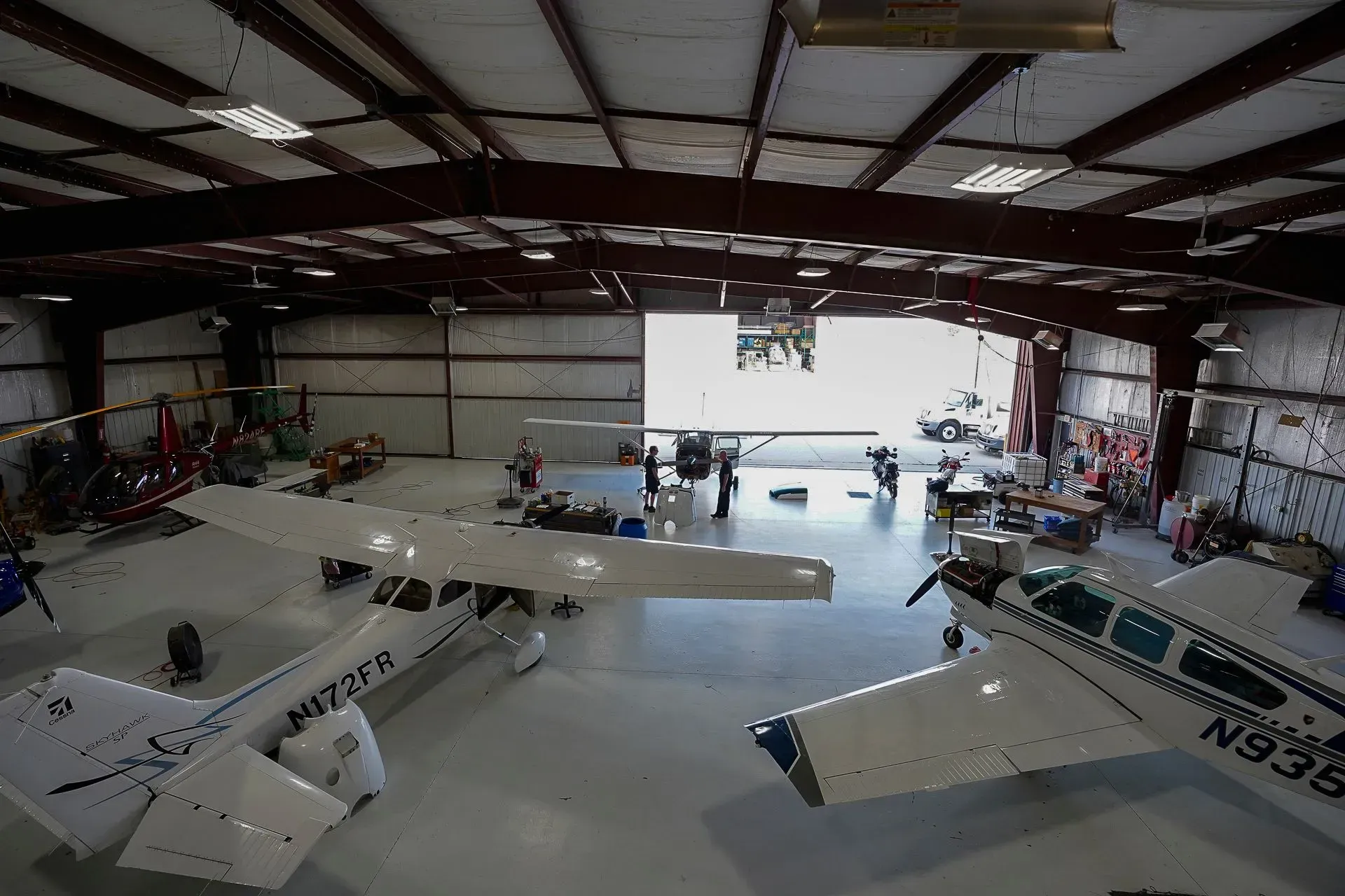 Small airplane inside a hangar with tools and equipment scattered around.