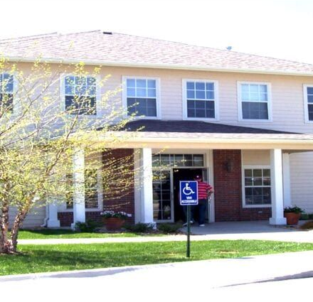 Accessible building entrance with blue wheelchair parking sign in front