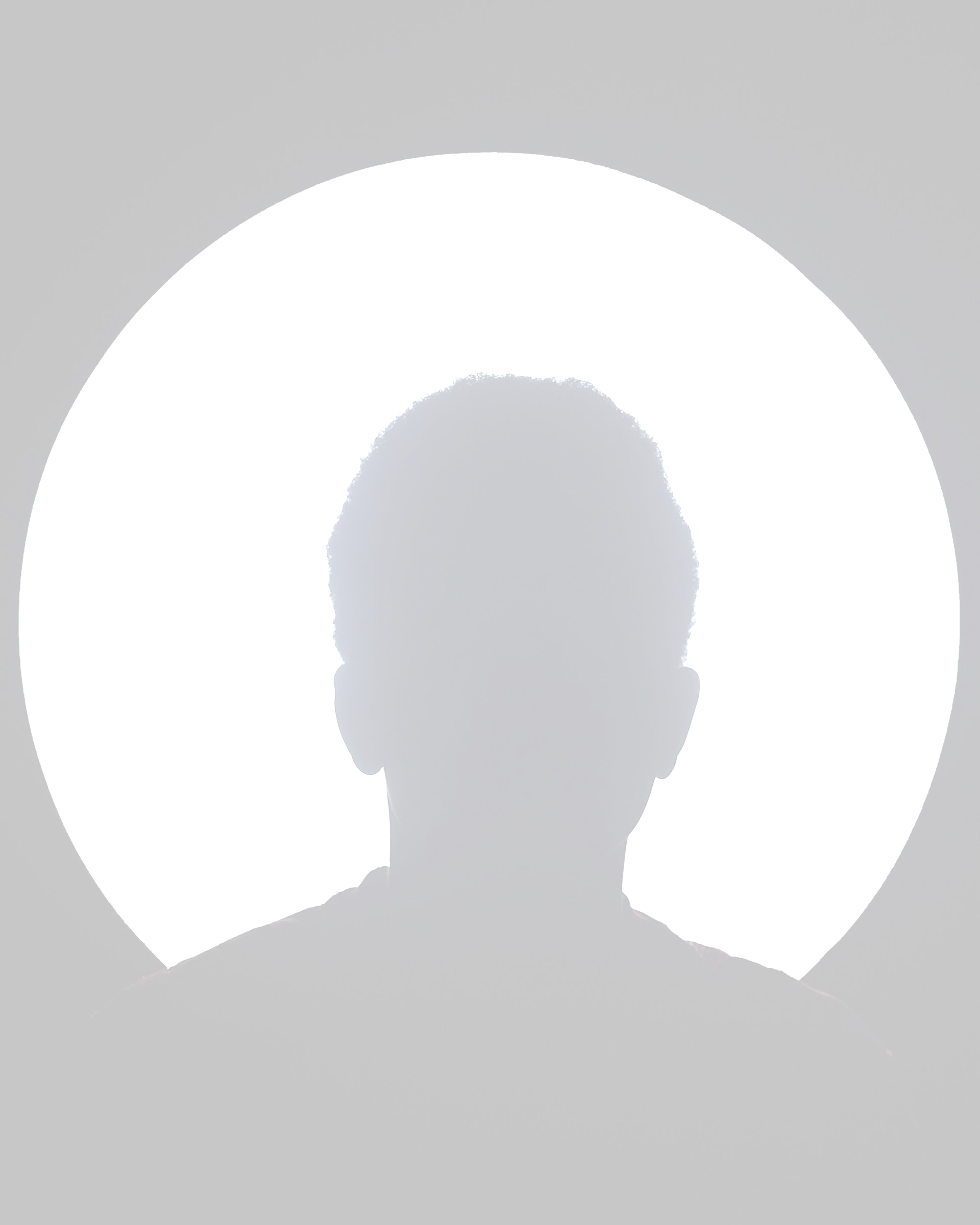 Dark silhouette of a person centered before a bright white circular background