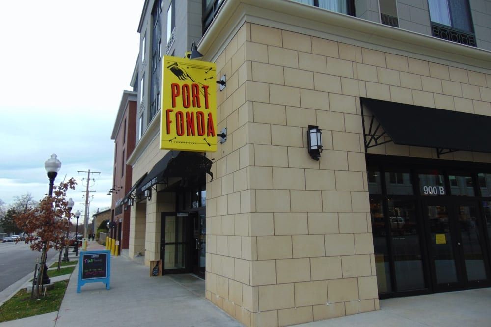 Corner storefront with a yellow “Port Cannery” sign on a sidewalk by the water