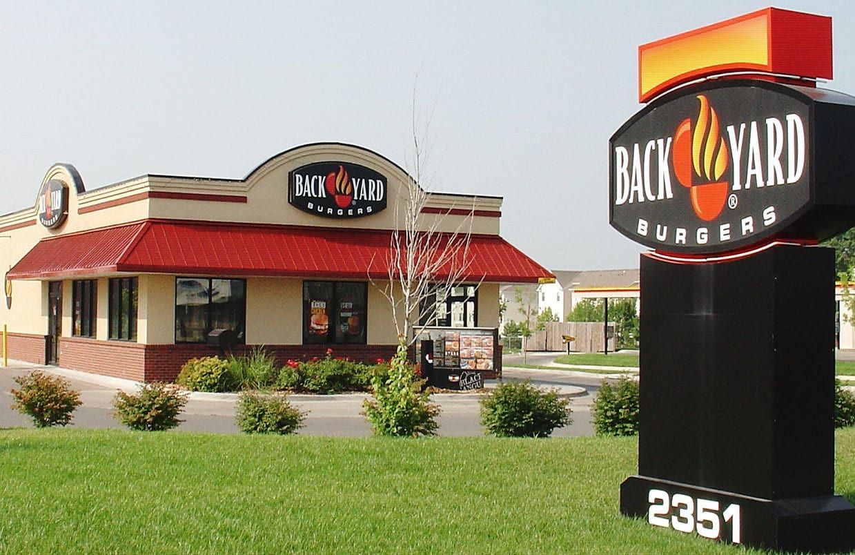Backyard Burgers restaurant with red roof and sign, viewed from the parking lot with address 2351.