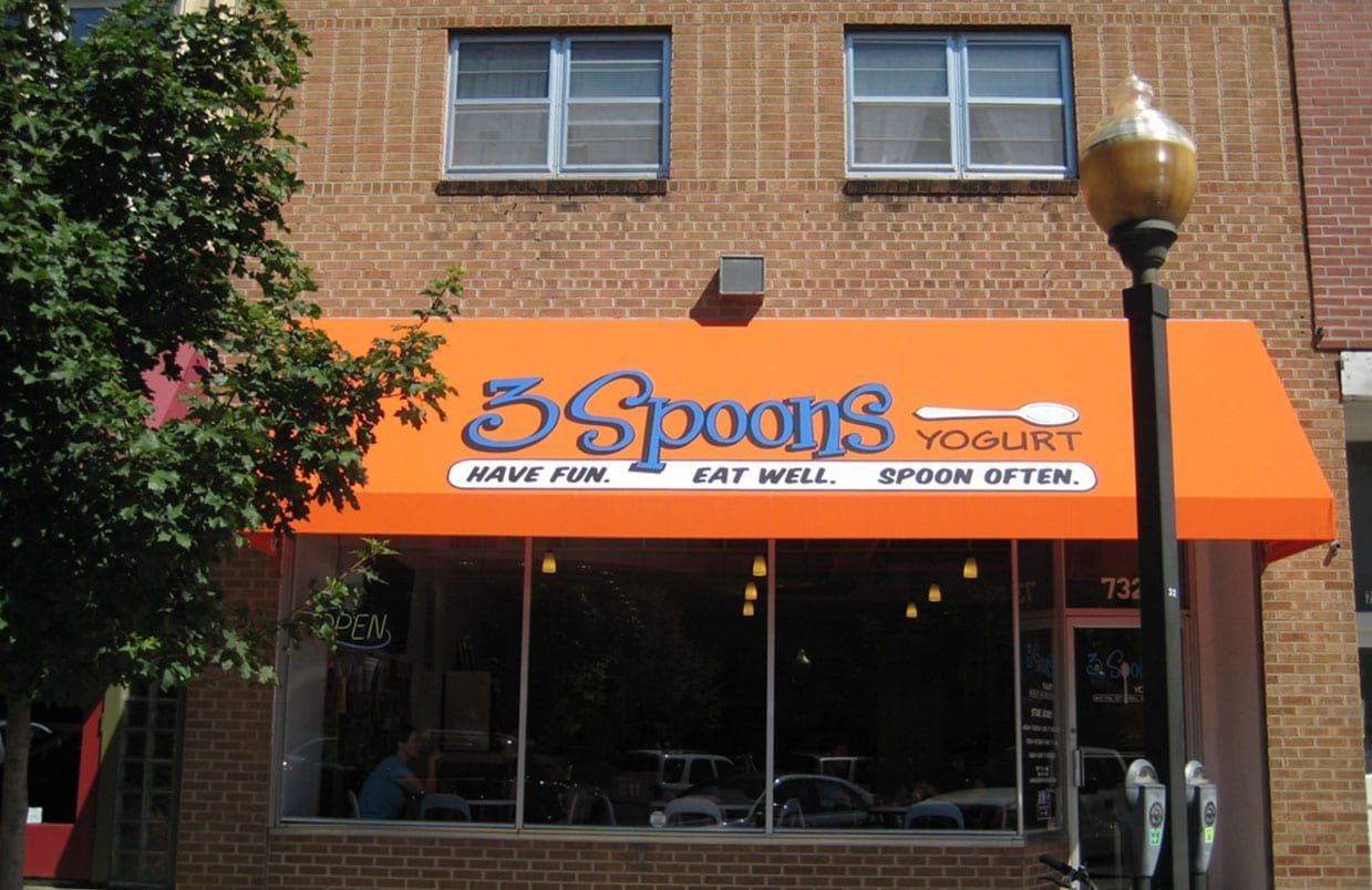 Front of 5 Spoons Yogurt shop with orange awning and storefront windows