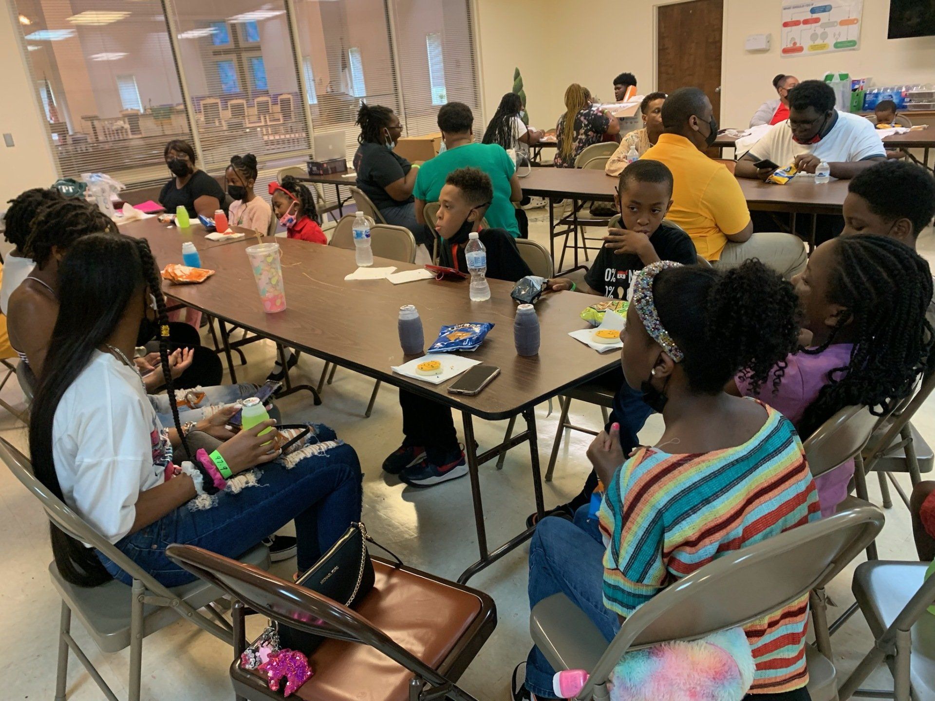 People seated at tables eating and socializing in a room.