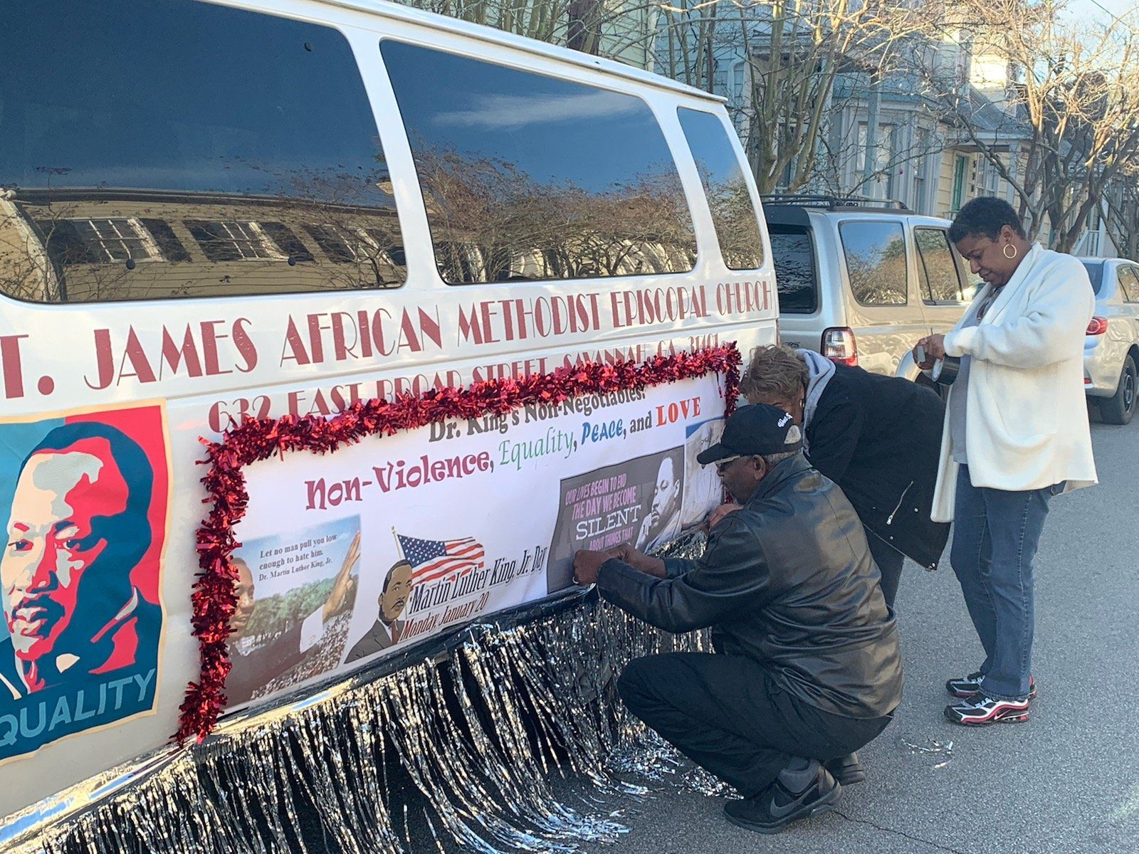 People decorating a float with Martin Luther King Jr. images and 