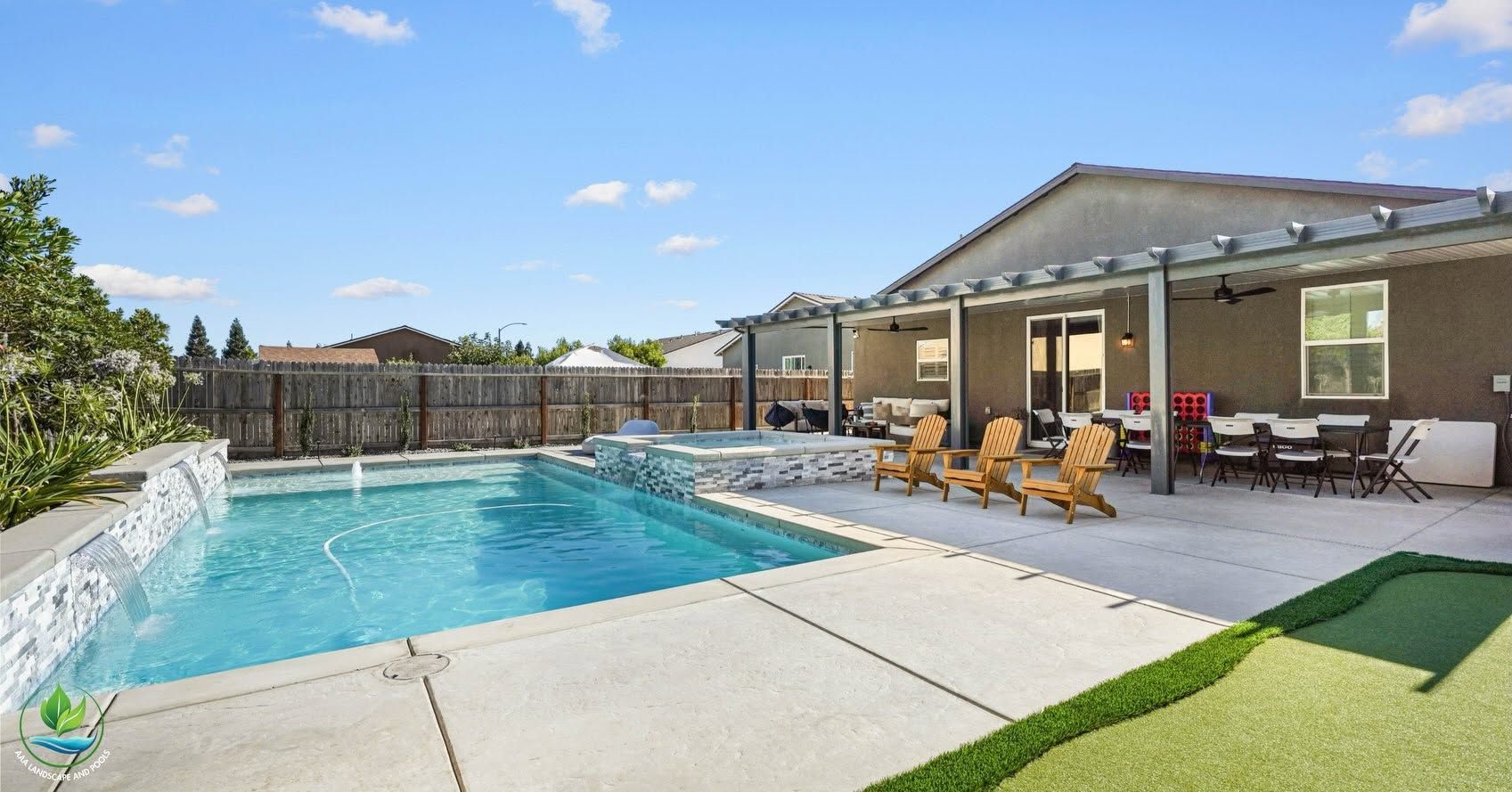Backyard with a swimming pool, patio seating, and a covered outdoor lounge beside a house.