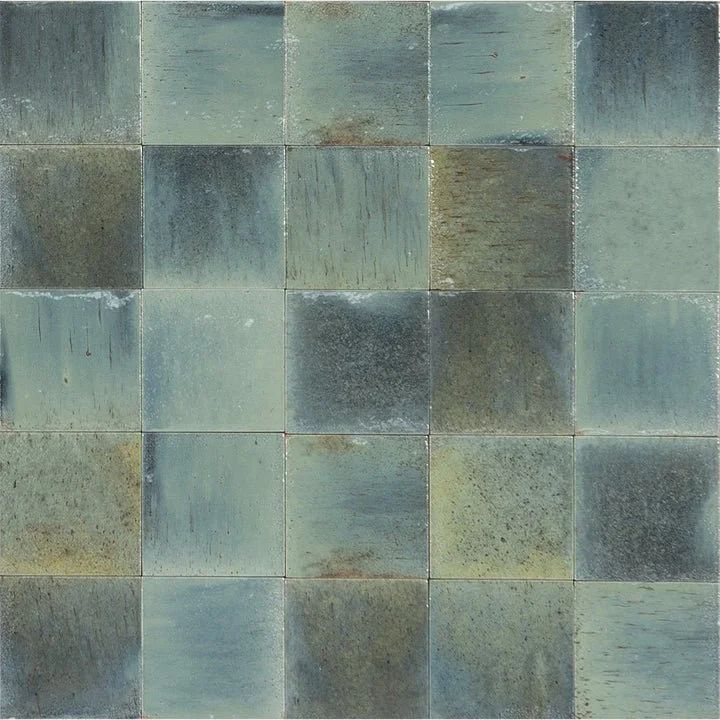Abstract mosaic of blue-green and gray square tiles with a weathered, textured surface
