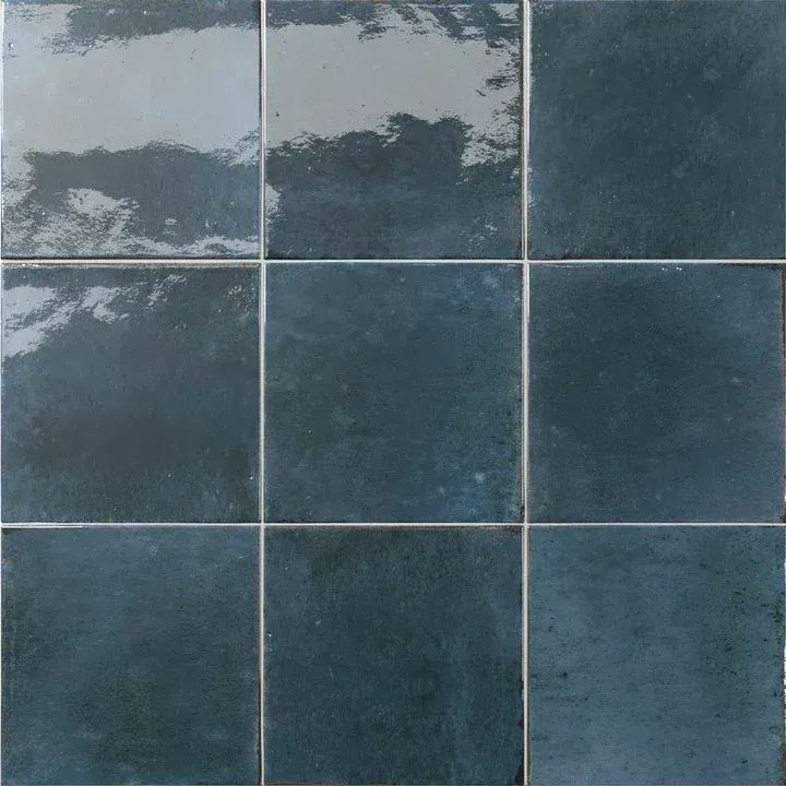 Blue-gray tiled wall with a weathered, patchy surface and visible grout lines