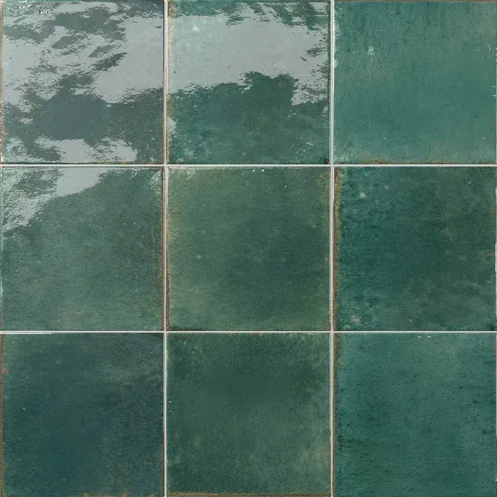 Teal ceramic tiles with gray grout and a worn, cloudy white patch in the upper left
