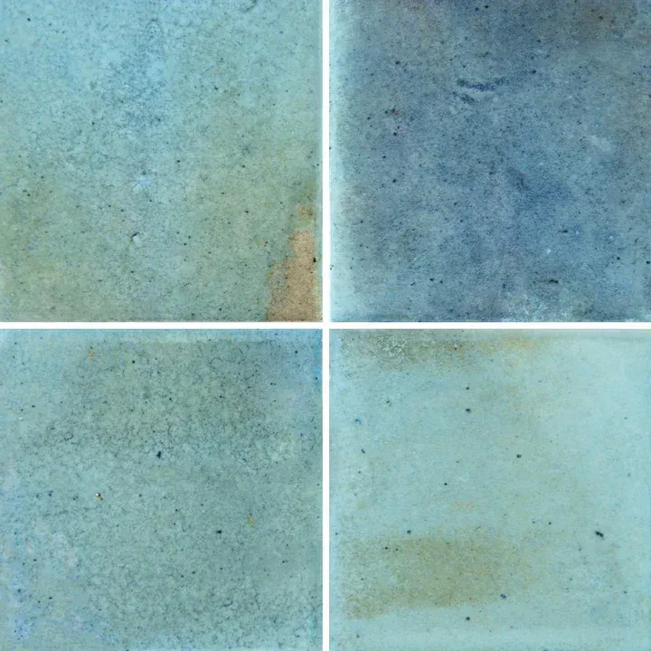 Four light blue-green textured tiles divided by white grout lines in a 2x2 grid