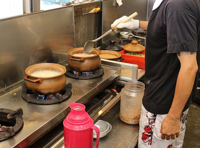 一個男人正在廚房裡做飯,爐子上放著鍋碗瓢盆。