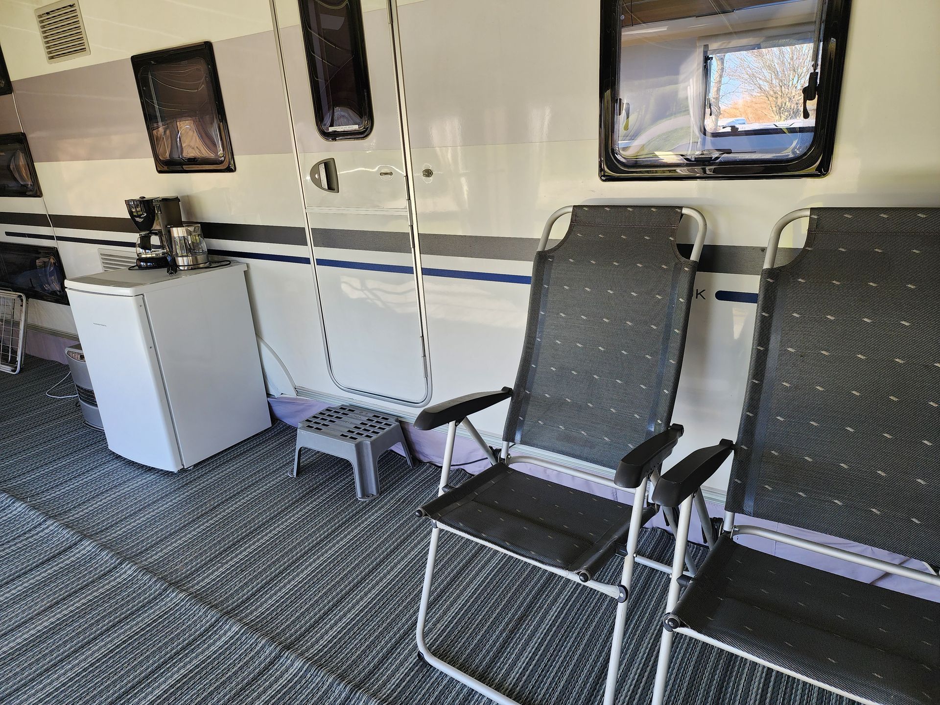 Zwarte campingstoelen, klaar om lekker te relaxen in de voortent.