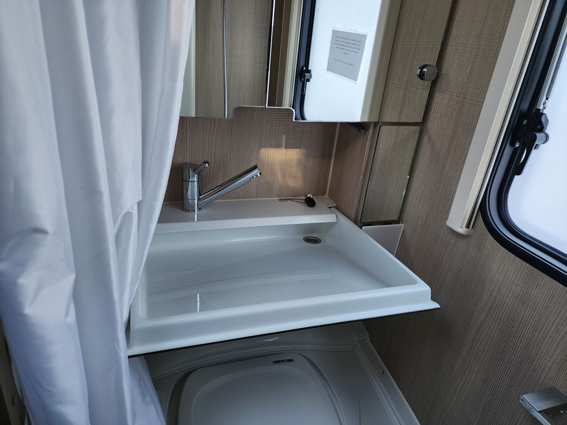 Wastafel en spiegel in de badkamer van de caravan.