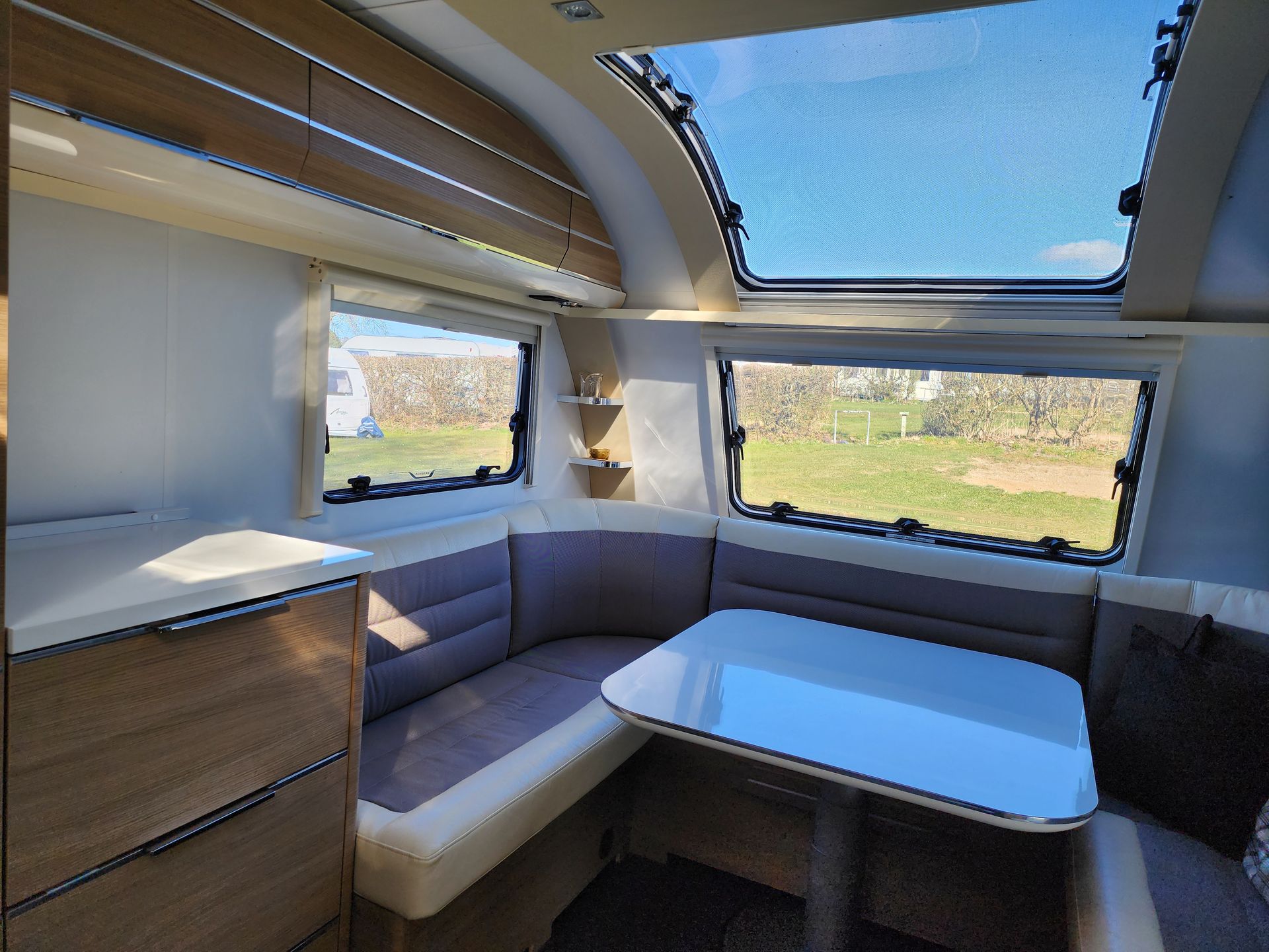 Gezellige zithoek met tafel in de caravan.