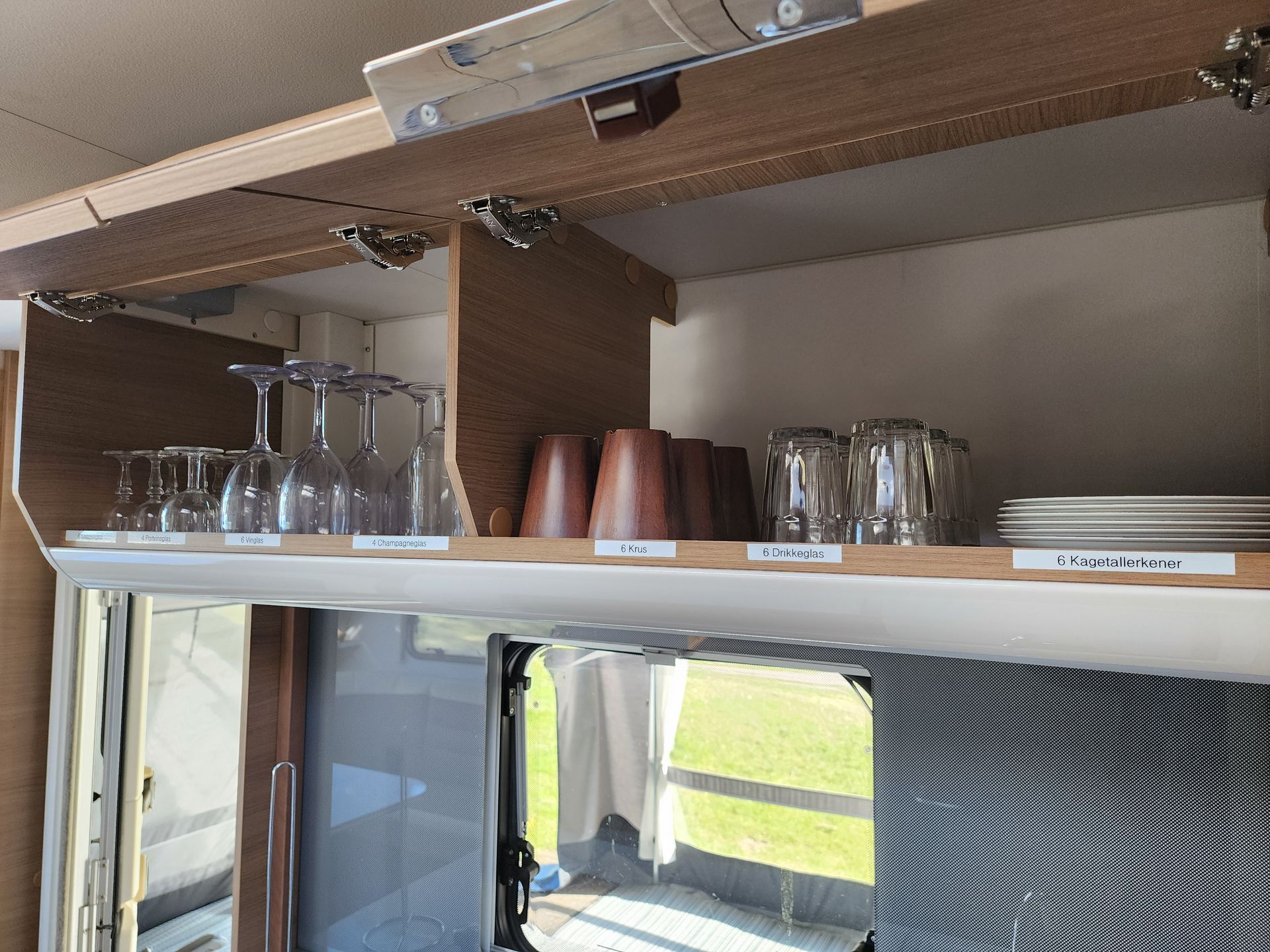 Kastjes met glazen en kopjes in de keuken van de caravan.