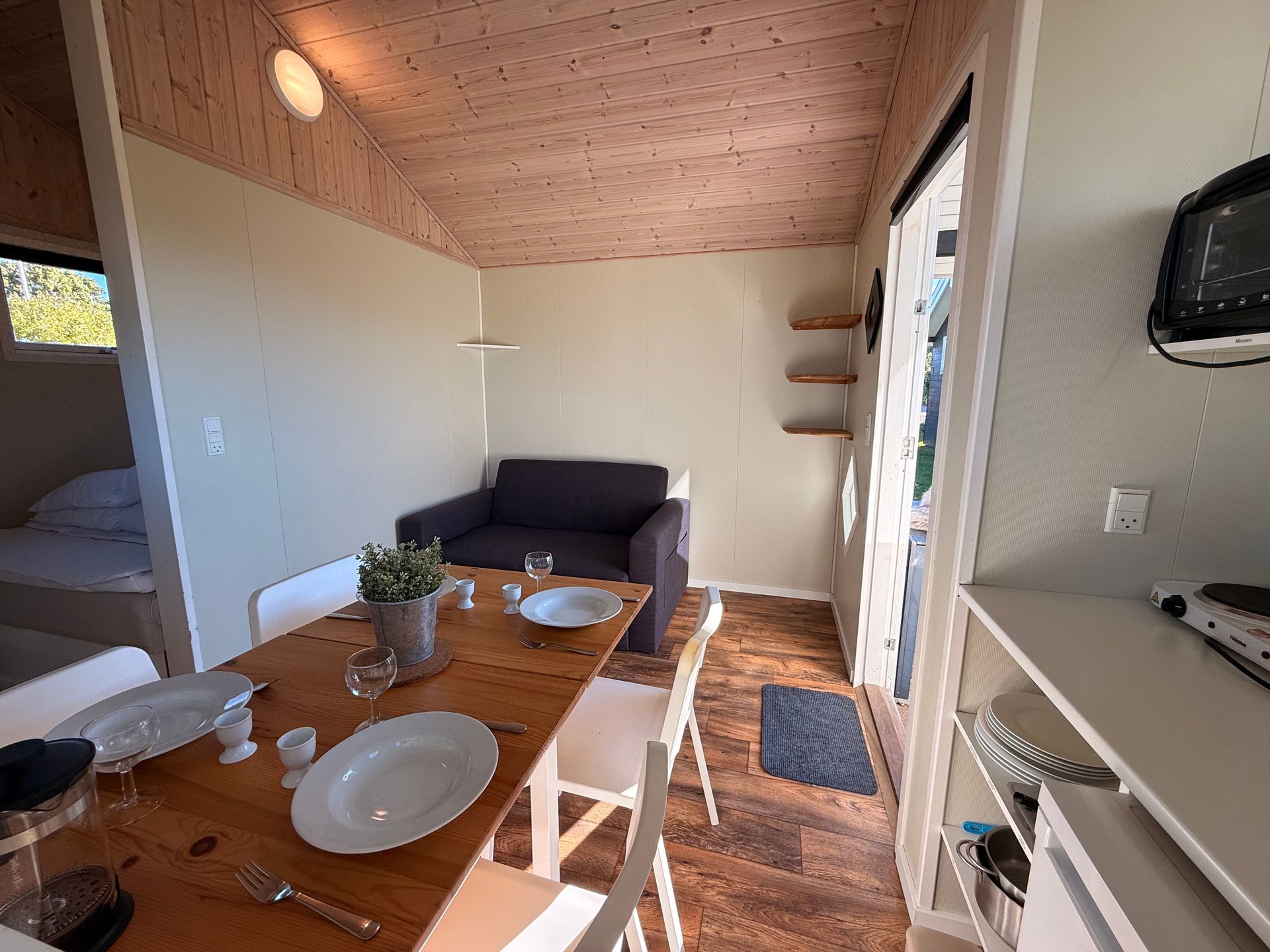 Lille sofaområde i den lyse og venlige campinghytte.