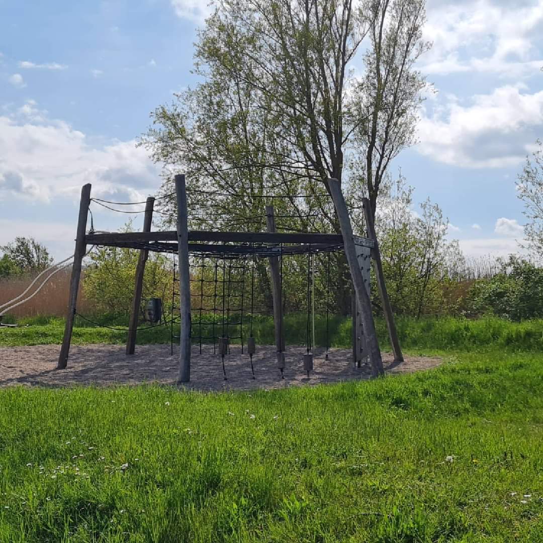 Stort klatrestativ med sort net til børn på legepladsen.