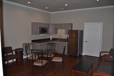kitchen and dining area with dark wood floor, black dining set, and stainless refrigerator.