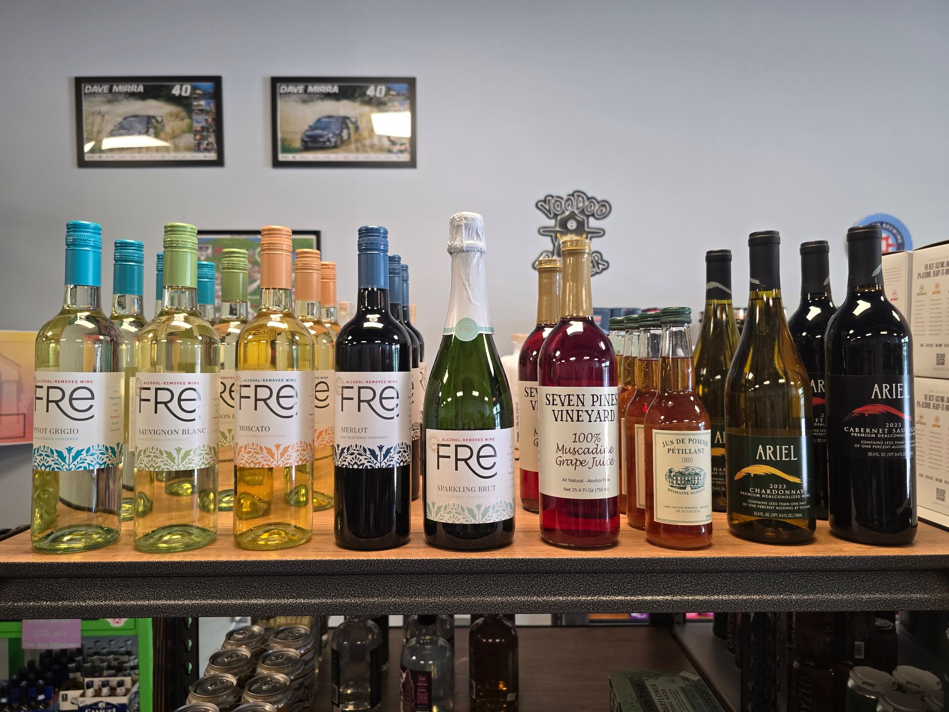 Assorted wine and liquor bottles lined up on shelves against a gray wall